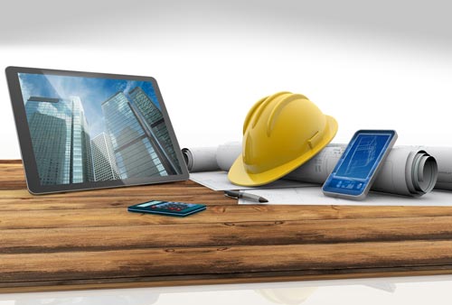 Yellow hard hat with electronics and blueprints