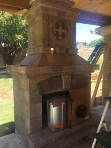 New outdoor fireplace installed with a covered patio