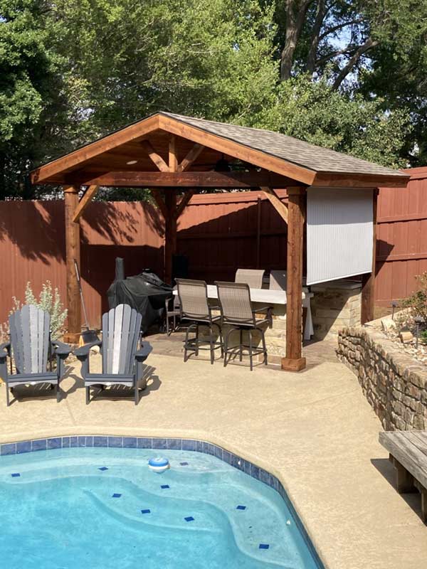 A outdoor kitchen covered by a pergola