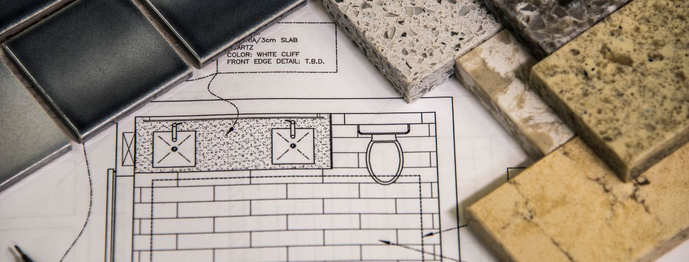 Bathroom blueprint with two sinks and tile flooring, surrounded by countertop and tile samples in various colors and textures.