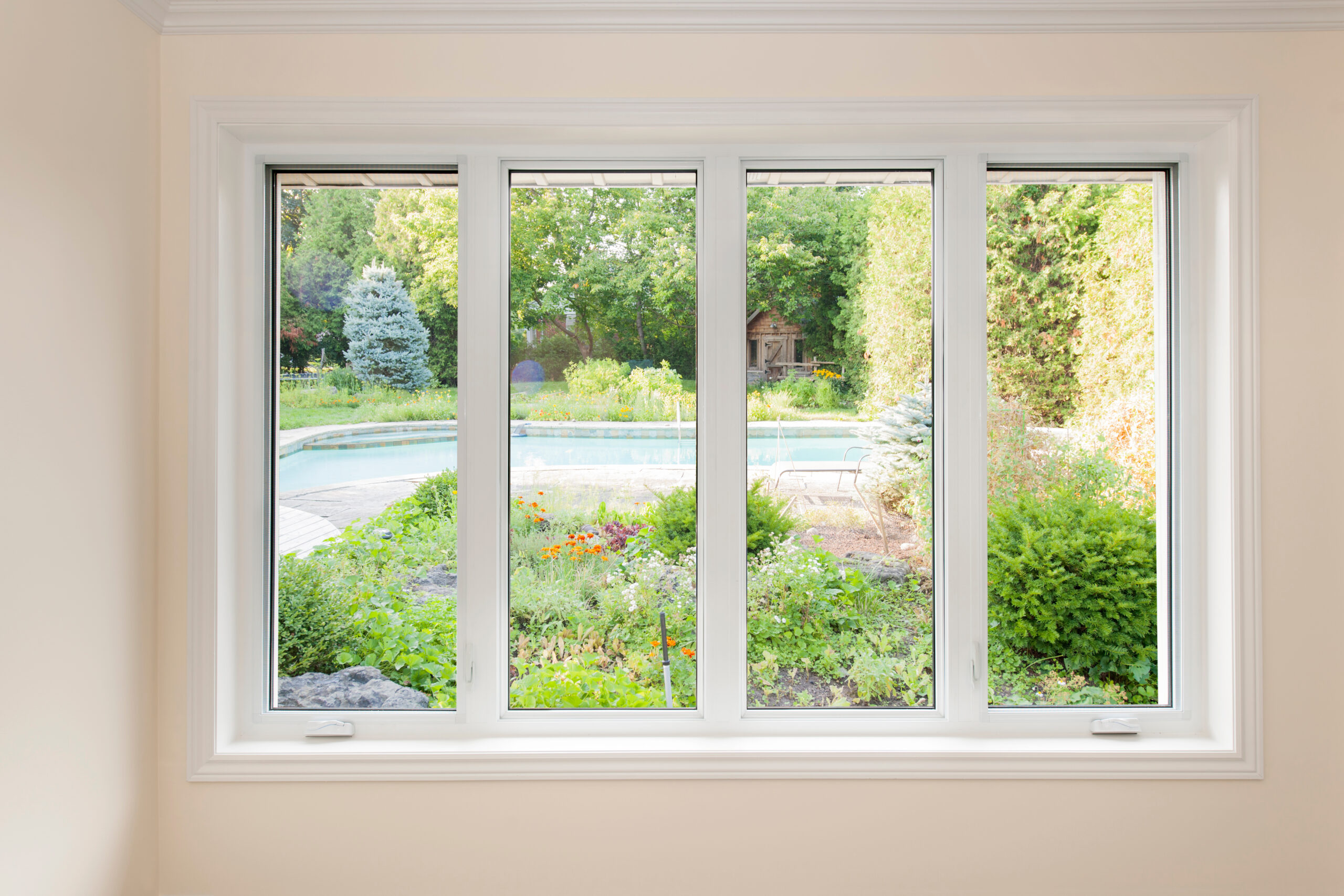 Casement windows with a view of a summer backyard